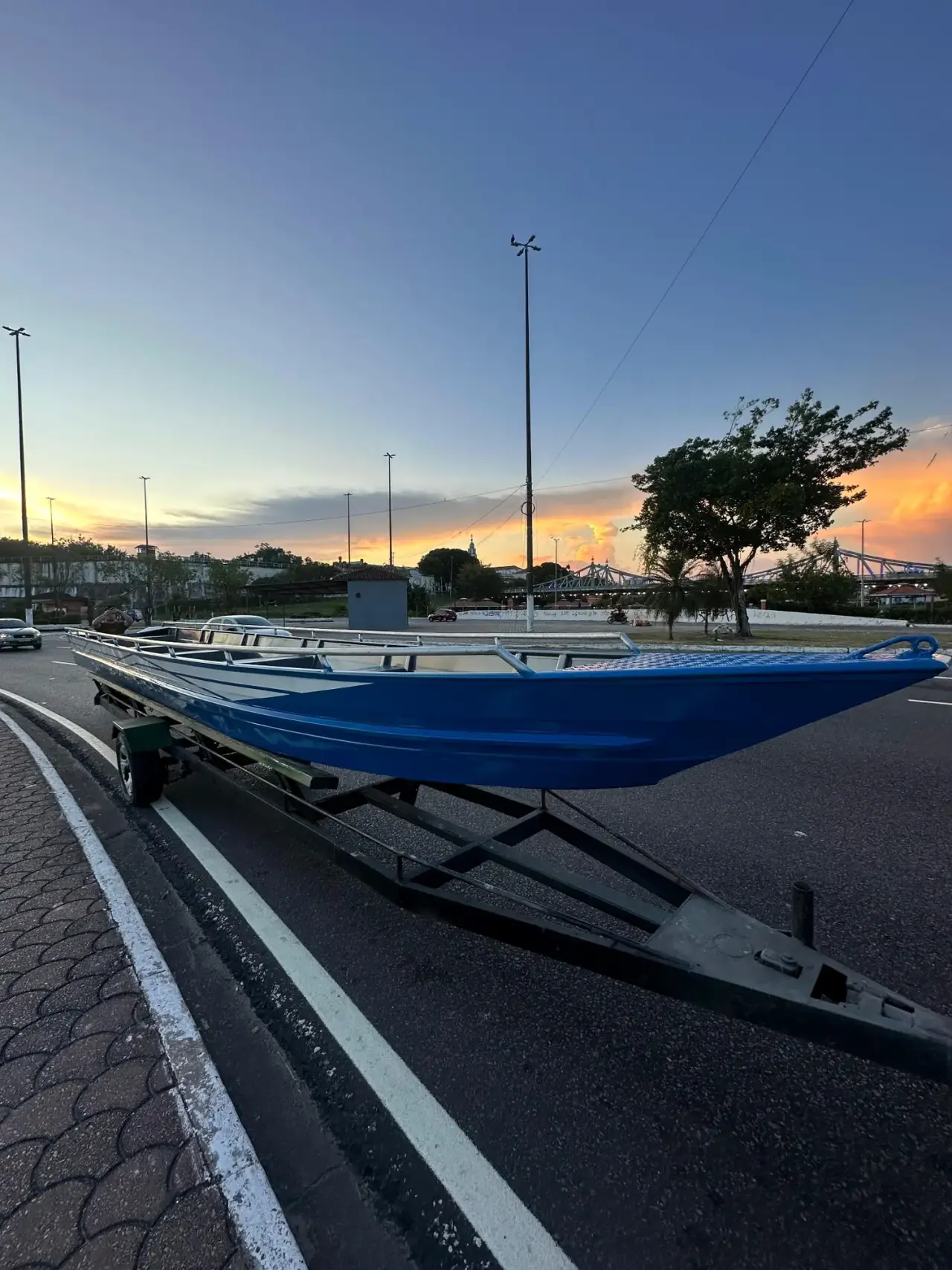 Canoa de alumínio azul em reboque ao pôr do sol